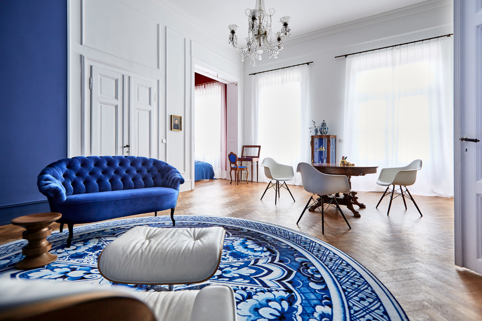 Immagine di un ampio soggiorno contemporaneo aperto con sala formale, pareti blu, pavimento in legno massello medio, TV nascosta, pavimento marrone e nessun camino