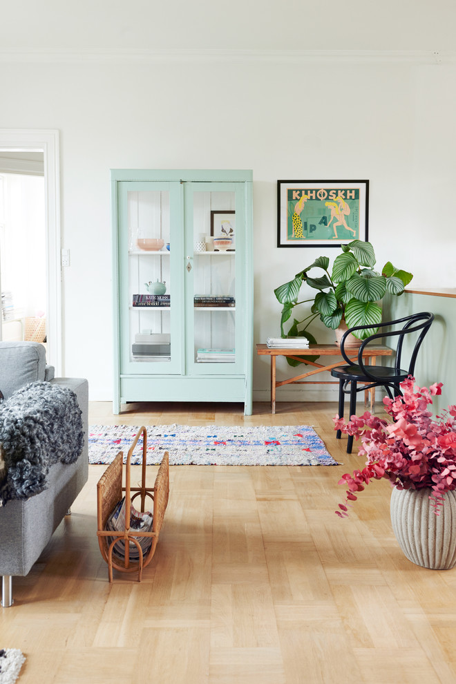 Inspiration för minimalistiska vardagsrum, med vita väggar och ljust trägolv