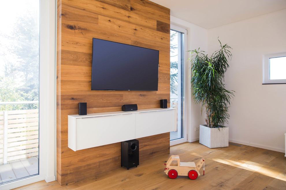 Mittelgroßes Modernes Wohnzimmer ohne Kamin mit weißer Wandfarbe, braunem Holzboden, TV-Wand und braunem Boden in Nürnberg