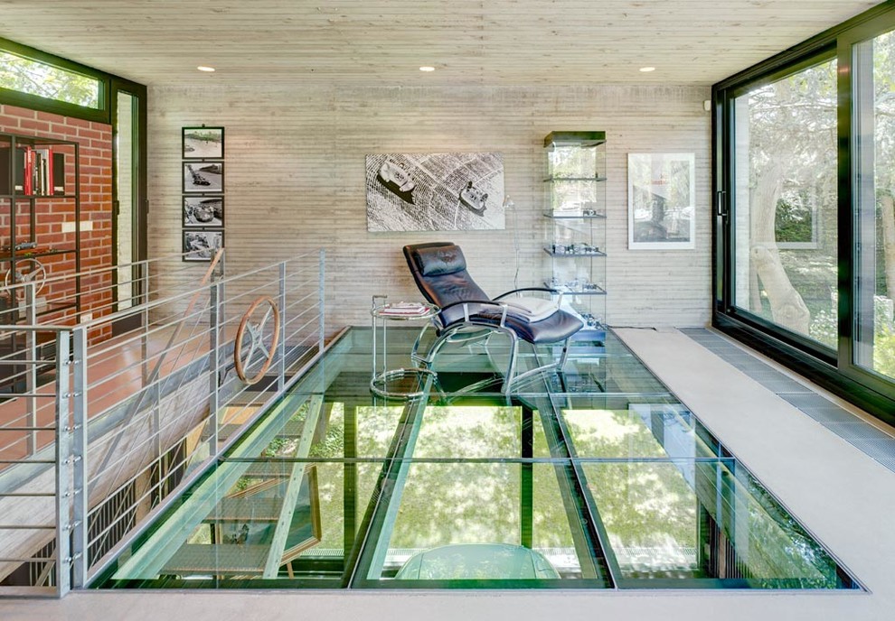 Fernseherloses, Großes Industrial Wohnzimmer ohne Kamin, im Loft-Stil mit grauer Wandfarbe und Betonboden in Köln