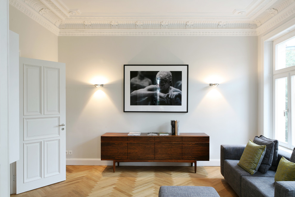 Diseño de sala de estar cerrada contemporánea de tamaño medio con suelo de madera clara y paredes blancas