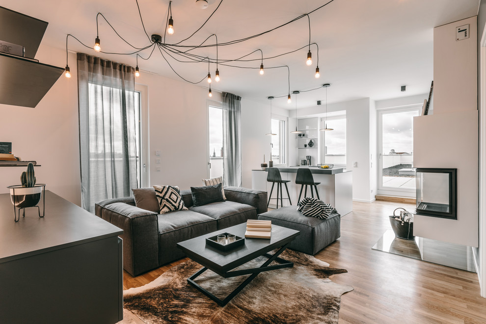 Offenes Modernes Wohnzimmer mit weißer Wandfarbe, braunem Holzboden und braunem Boden in Berlin