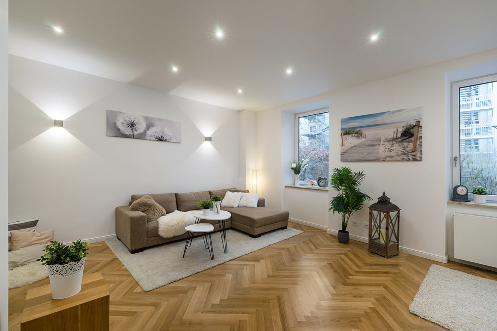 This is an example of a medium sized coastal enclosed games room in Munich with white walls, medium hardwood flooring, no fireplace, no tv and brown floors.