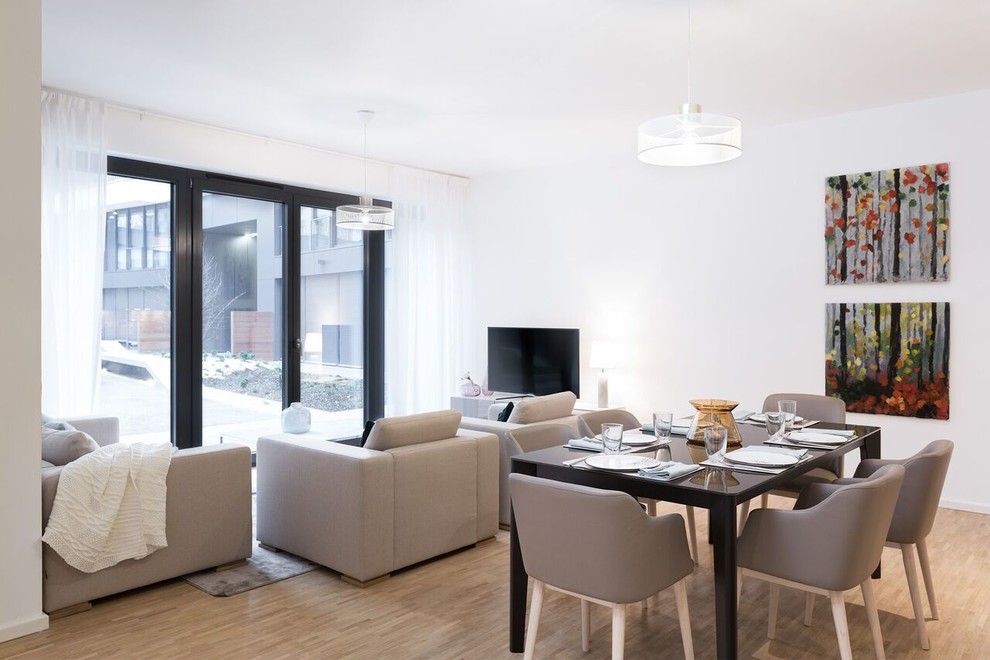 Ispirazione per un piccolo soggiorno design con pareti bianche, pavimento in legno massello medio e pavimento marrone