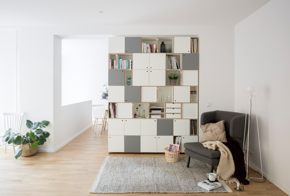 Mittelgroße, Fernseherlose, Abgetrennte Skandinavische Bibliothek ohne Kamin mit weißer Wandfarbe, hellem Holzboden und braunem Boden in Berlin