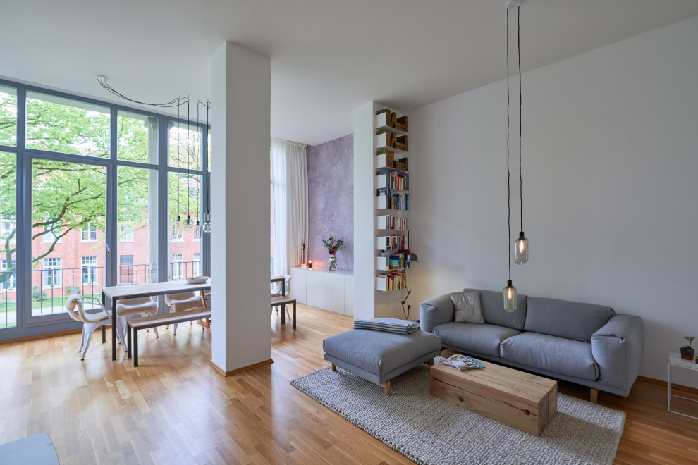 Idee per un soggiorno contemporaneo aperto con pareti bianche, pavimento in legno massello medio e pavimento marrone