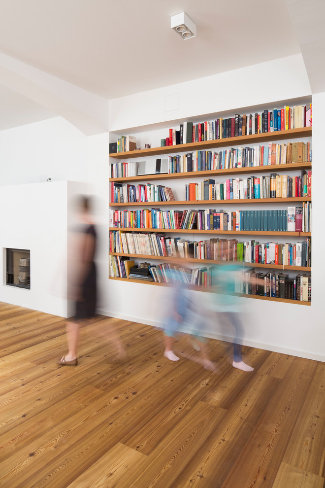 Mittelgroße, Fernseherlose, Abgetrennte Moderne Bibliothek ohne Kamin mit weißer Wandfarbe, hellem Holzboden und braunem Boden in München