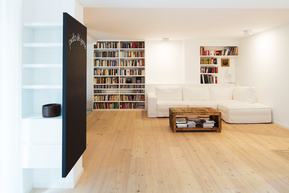 Esempio di un soggiorno contemporaneo di medie dimensioni e chiuso con libreria, pareti bianche, parquet chiaro, nessun camino, nessuna TV e pavimento marrone