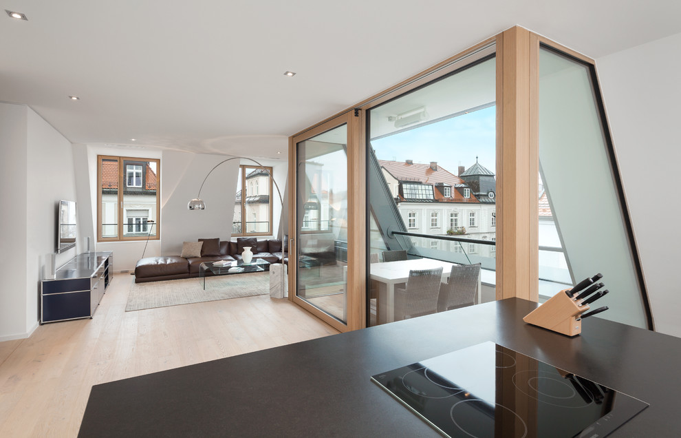 Großes, Offenes Modernes Wohnzimmer mit weißer Wandfarbe, hellem Holzboden und TV-Wand in München