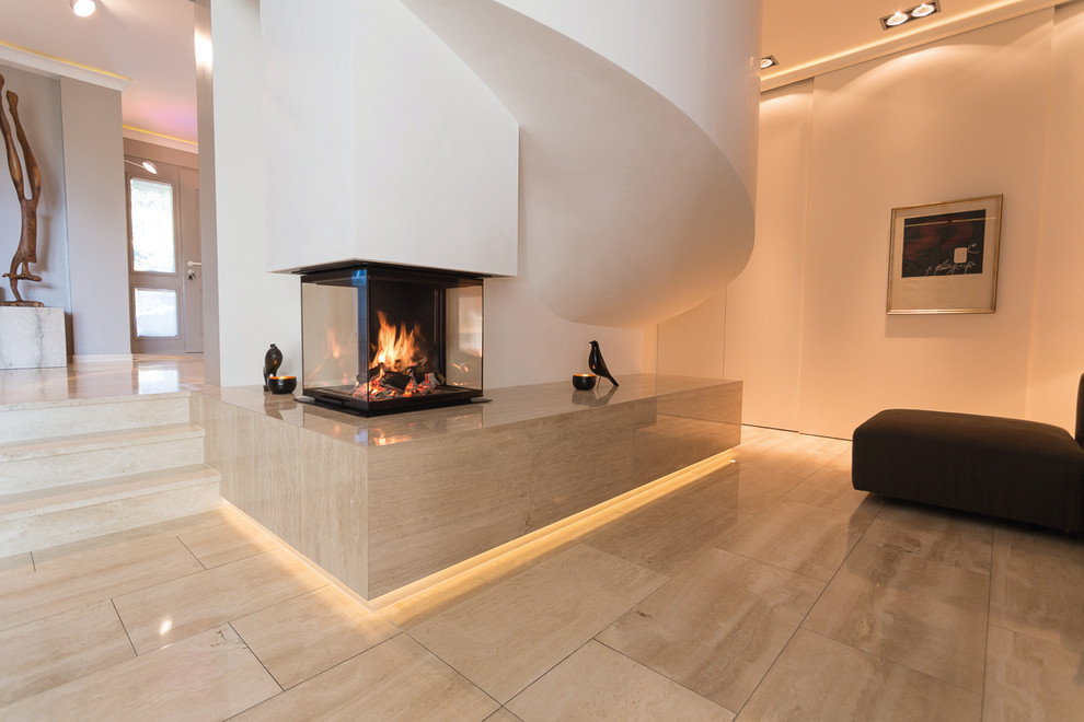 Idee per un soggiorno contemporaneo aperto con pareti bianche, pavimento in pietra calcarea e camino bifacciale