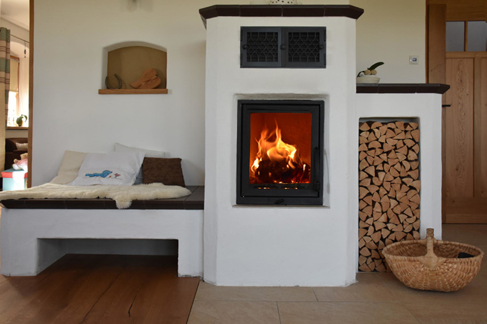Cette photo montre un salon chic avec un mur blanc, un sol en brique, un poêle à bois et un manteau de cheminée en plâtre.