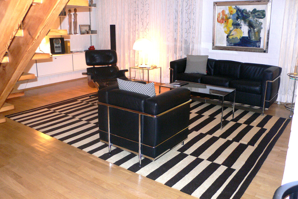 Imagen de salón minimalista de tamaño medio con paredes blancas y suelo de madera clara
