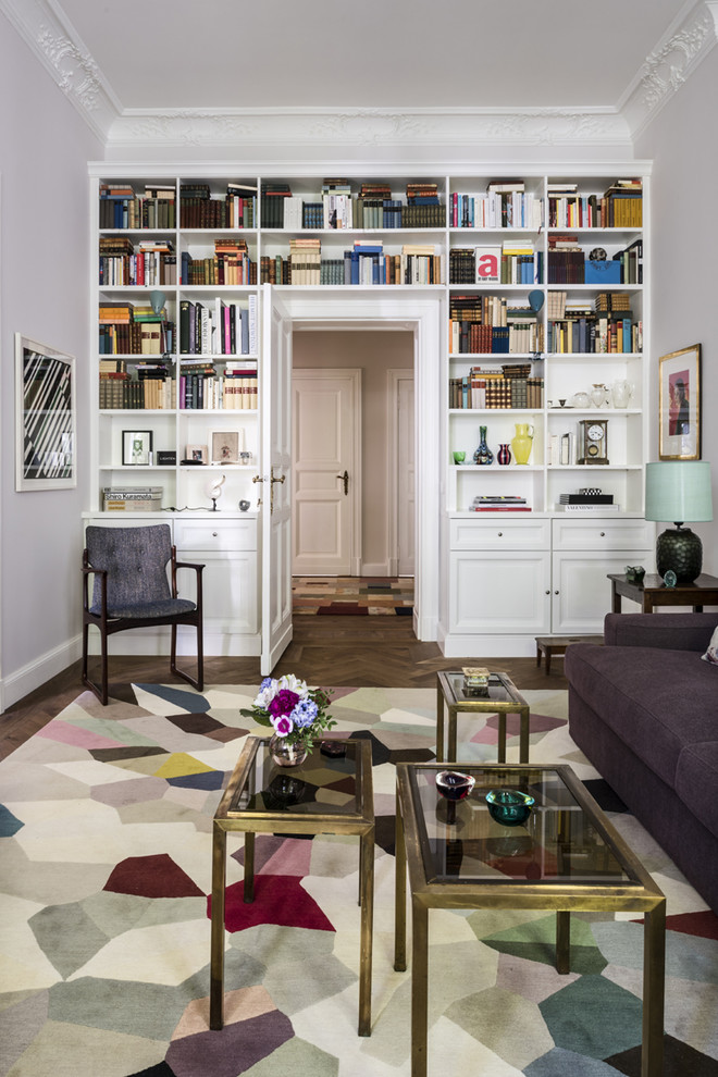 Foto de sala de estar con biblioteca cerrada clásica de tamaño medio sin chimenea y televisor con paredes blancas, suelo de madera en tonos medios y suelo marrón