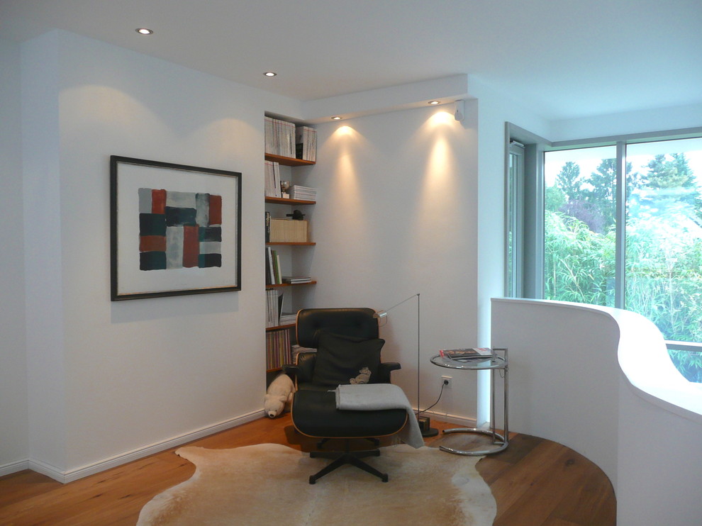 Modernes Wohnzimmer mit weißer Wandfarbe und braunem Holzboden in Düsseldorf