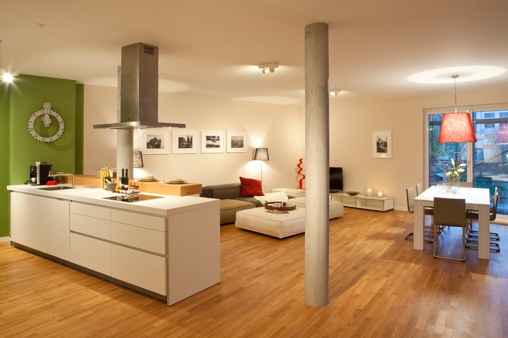 Cette photo montre une salle de séjour tendance de taille moyenne et ouverte avec un sol en bois brun, aucune cheminée, un téléviseur indépendant et un mur beige.