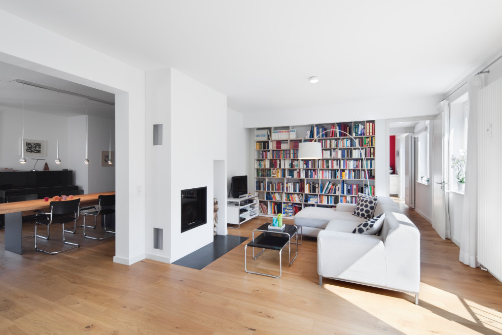 Modernes Wohnzimmer mit weißer Wandfarbe, Kamin, verputzter Kaminumrandung, freistehendem TV und braunem Boden in Düsseldorf