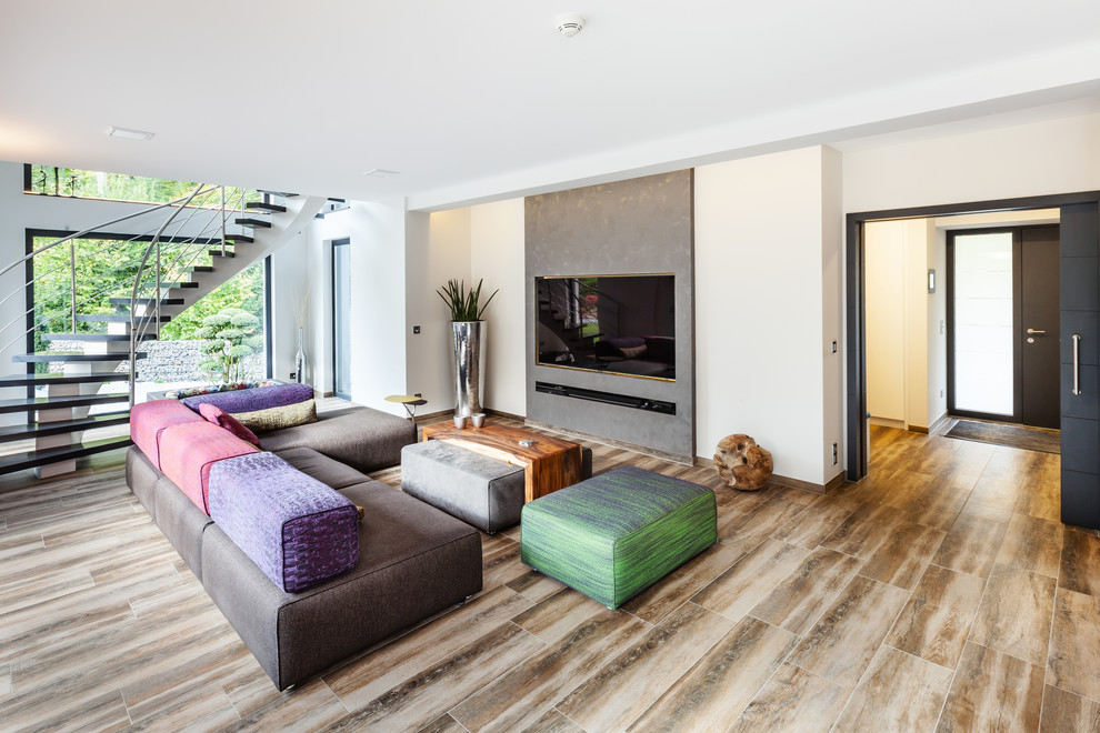 Источник вдохновения для домашнего уюта: огромная открытая гостиная комната в стиле фьюжн с белыми стенами и телевизором на стене