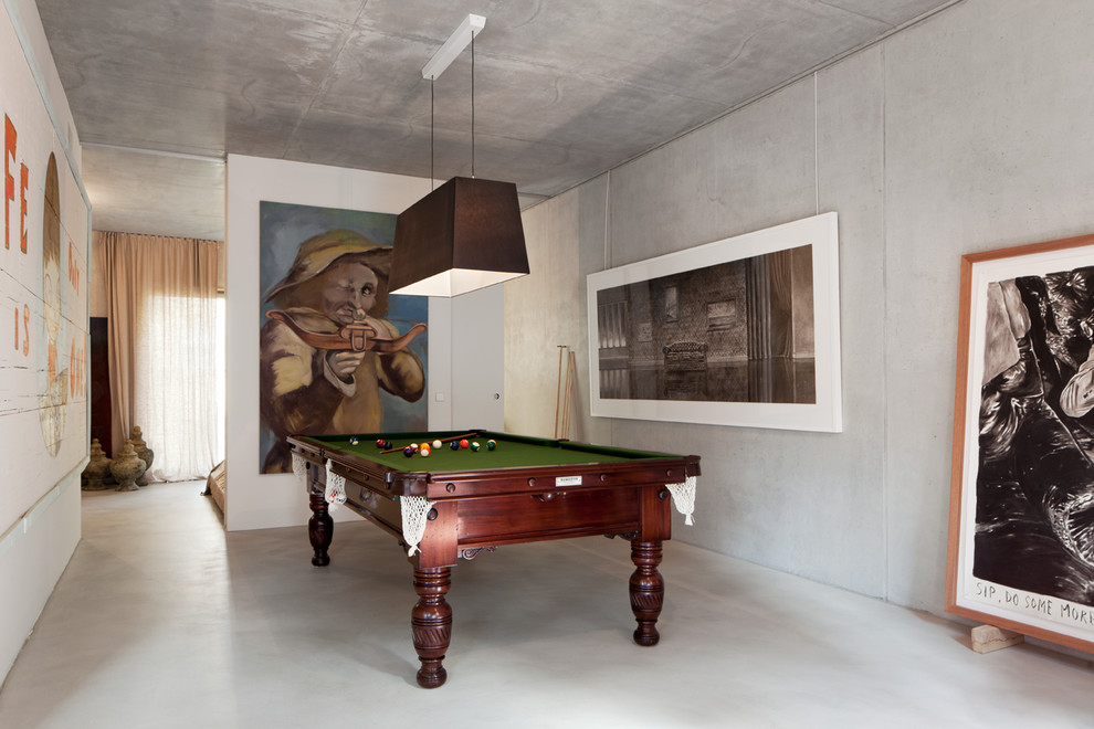 Diseño de sala de estar cerrada contemporánea de tamaño medio sin chimenea con paredes grises y suelo de cemento