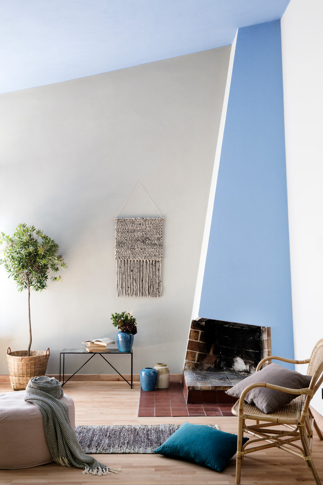 Fernseherloses Nordisches Wohnzimmer mit blauer Wandfarbe, Eckkamin und hellem Holzboden in Dresden