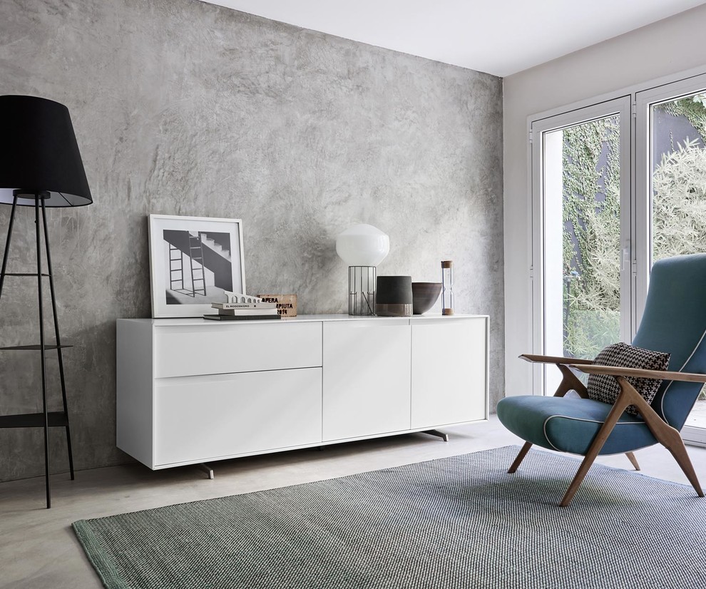Пример оригинального дизайна: большая изолированная гостиная комната в современном стиле с серыми стенами, серым полом, с книжными шкафами и полками, бетонным полом и фасадом камина из бетона без камина, телевизора