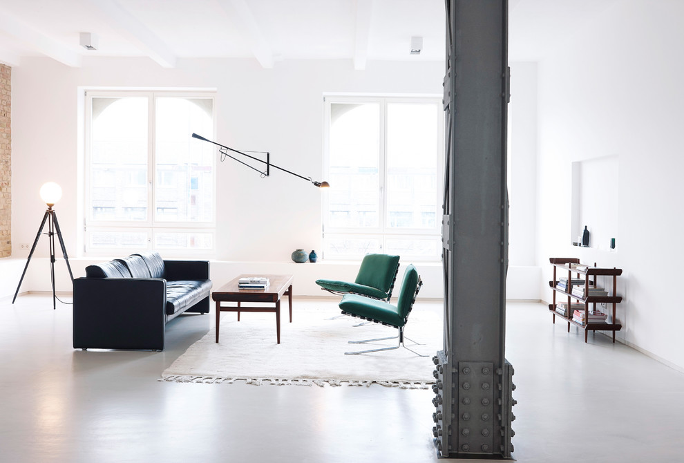 Retro Wohnzimmer mit weißer Wandfarbe, Betonboden und grauem Boden in Berlin