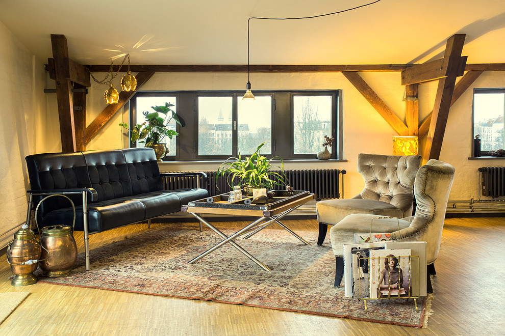 Offenes, Mittelgroßes Industrial Wohnzimmer mit gelber Wandfarbe, braunem Holzboden und braunem Boden in Berlin