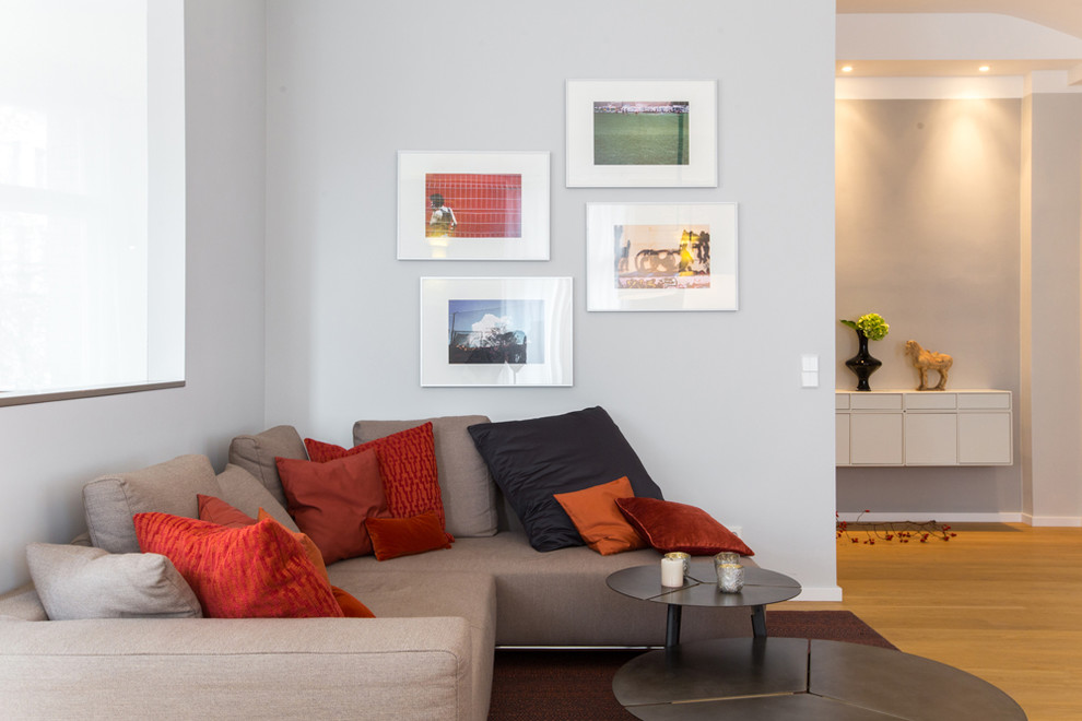 Immagine di un soggiorno minimal di medie dimensioni e stile loft con pareti grigie, parquet chiaro e pavimento marrone