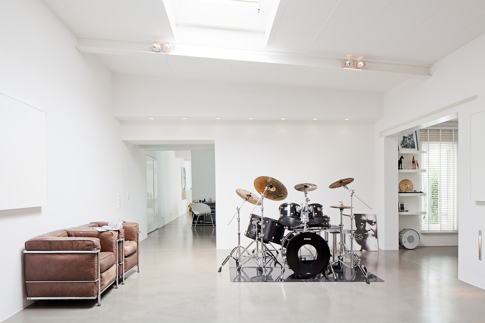 Источник вдохновения для домашнего уюта: большая гостиная комната в стиле модернизм с белыми стенами и бетонным полом без камина