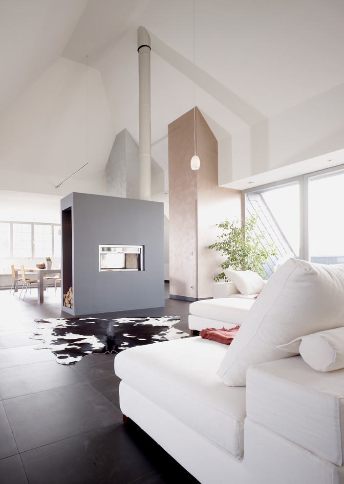 Réalisation d'une très grande salle de séjour design avec un mur blanc, une cheminée double-face et un sol noir.