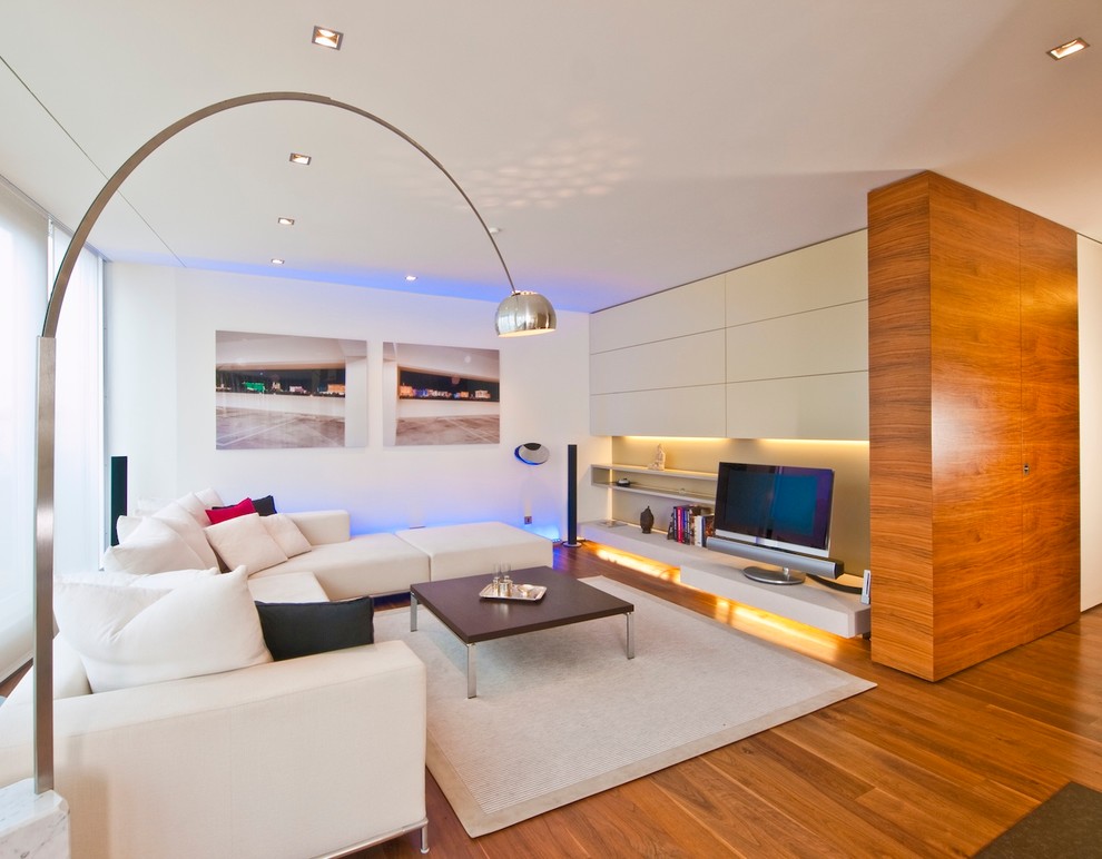 Ejemplo de sala de estar abierta contemporánea de tamaño medio sin chimenea con paredes blancas, suelo de madera en tonos medios y televisor independiente