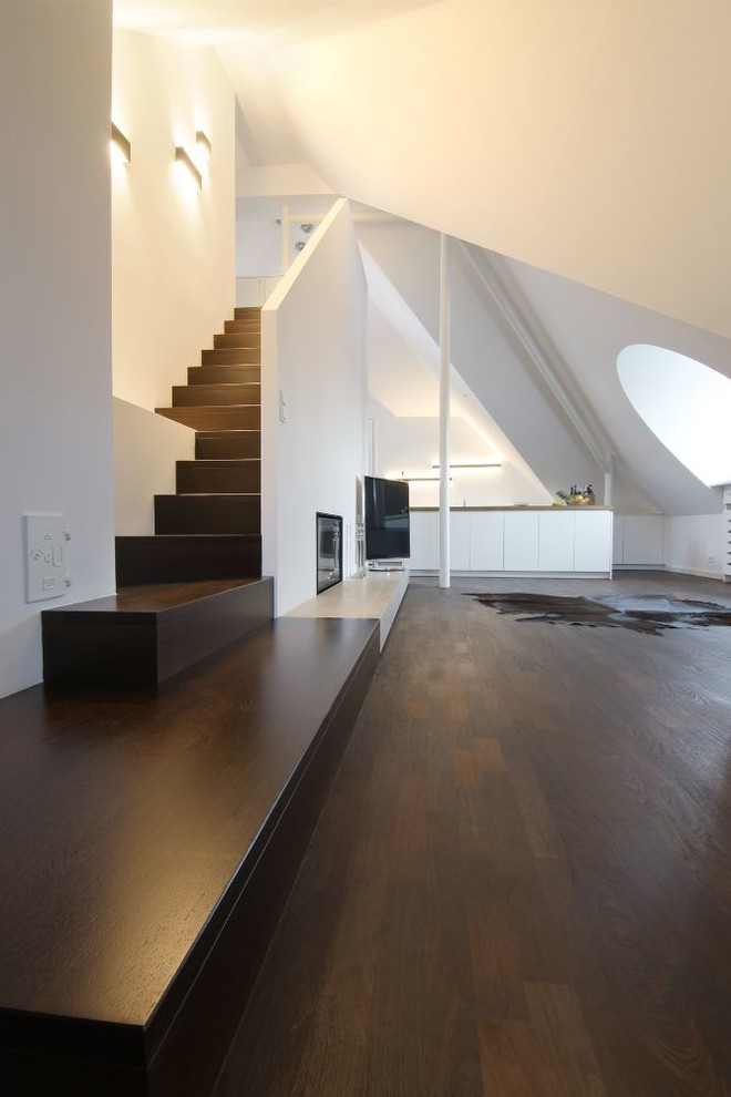 Geräumiges Modernes Wohnzimmer mit dunklem Holzboden, freistehendem TV und weißer Wandfarbe in München