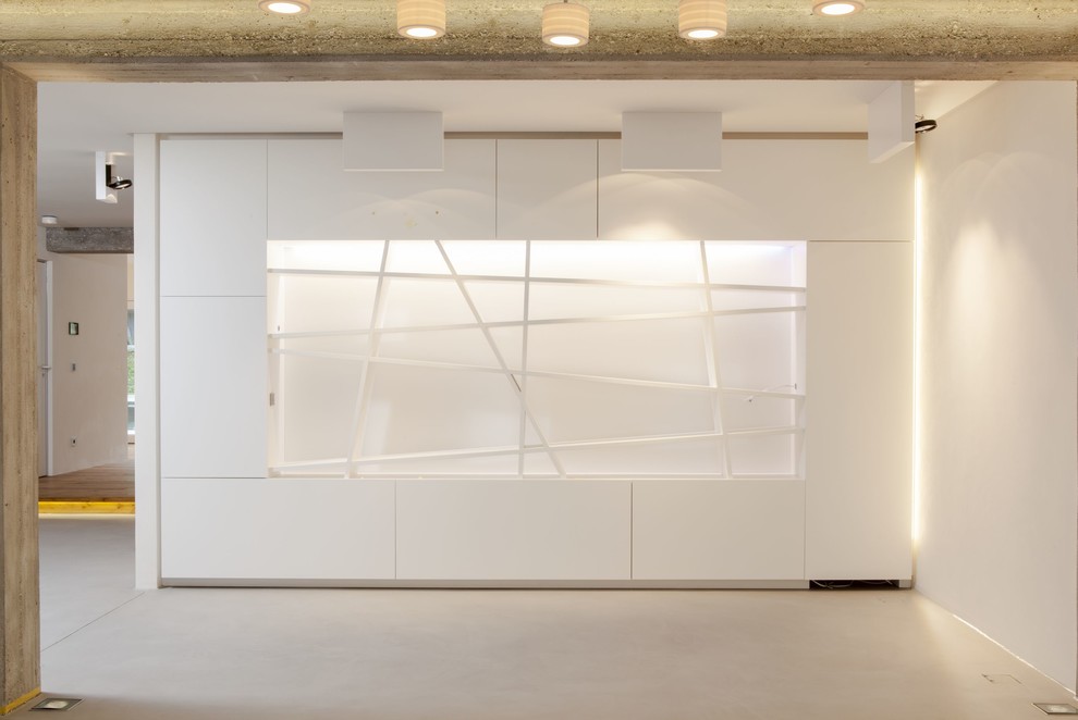 Geräumiges, Offenes Modernes Wohnzimmer mit weißer Wandfarbe und Betonboden in Stuttgart