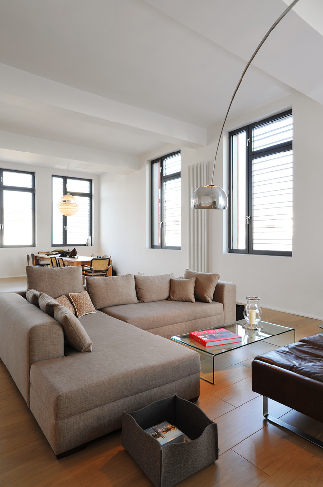 Ispirazione per un soggiorno design di medie dimensioni e aperto con pareti bianche e pavimento in legno massello medio