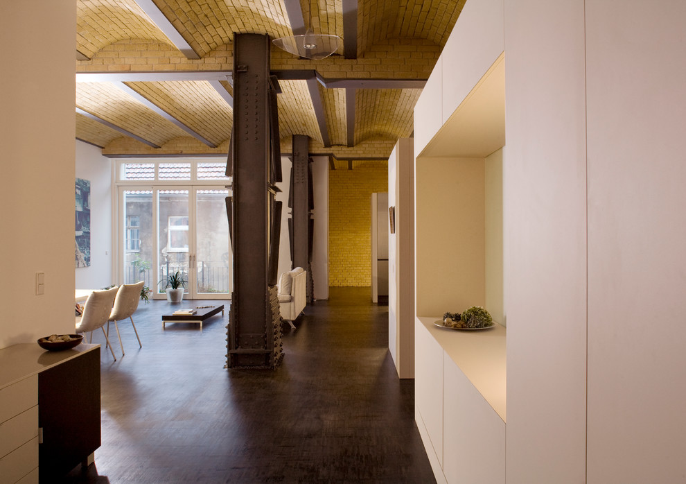 Diseño de salón tipo loft industrial con paredes blancas y suelo de linóleo