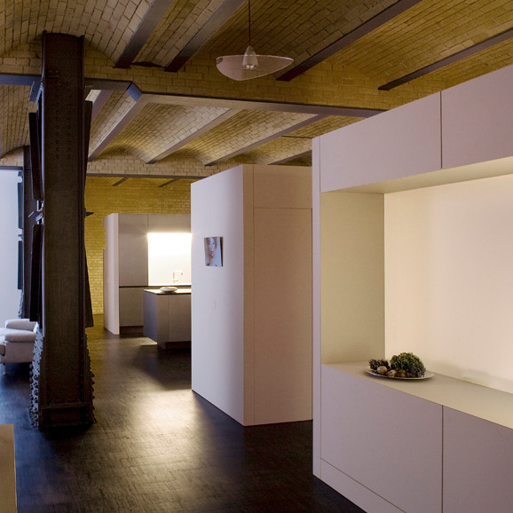Modelo de salón tipo loft industrial con paredes blancas y suelo de linóleo