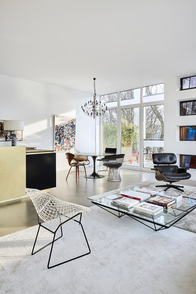 Mittelgroßes, Repräsentatives, Fernseherloses Modernes Wohnzimmer ohne Kamin, im Loft-Stil mit weißer Wandfarbe, Betonboden und grauem Boden in Köln