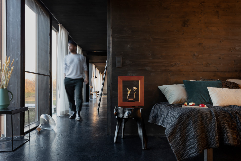 На фото: двухуровневая гостиная комната среднего размера в стиле фьюжн с черными стенами, бетонным полом и черным полом без камина, телевизора с