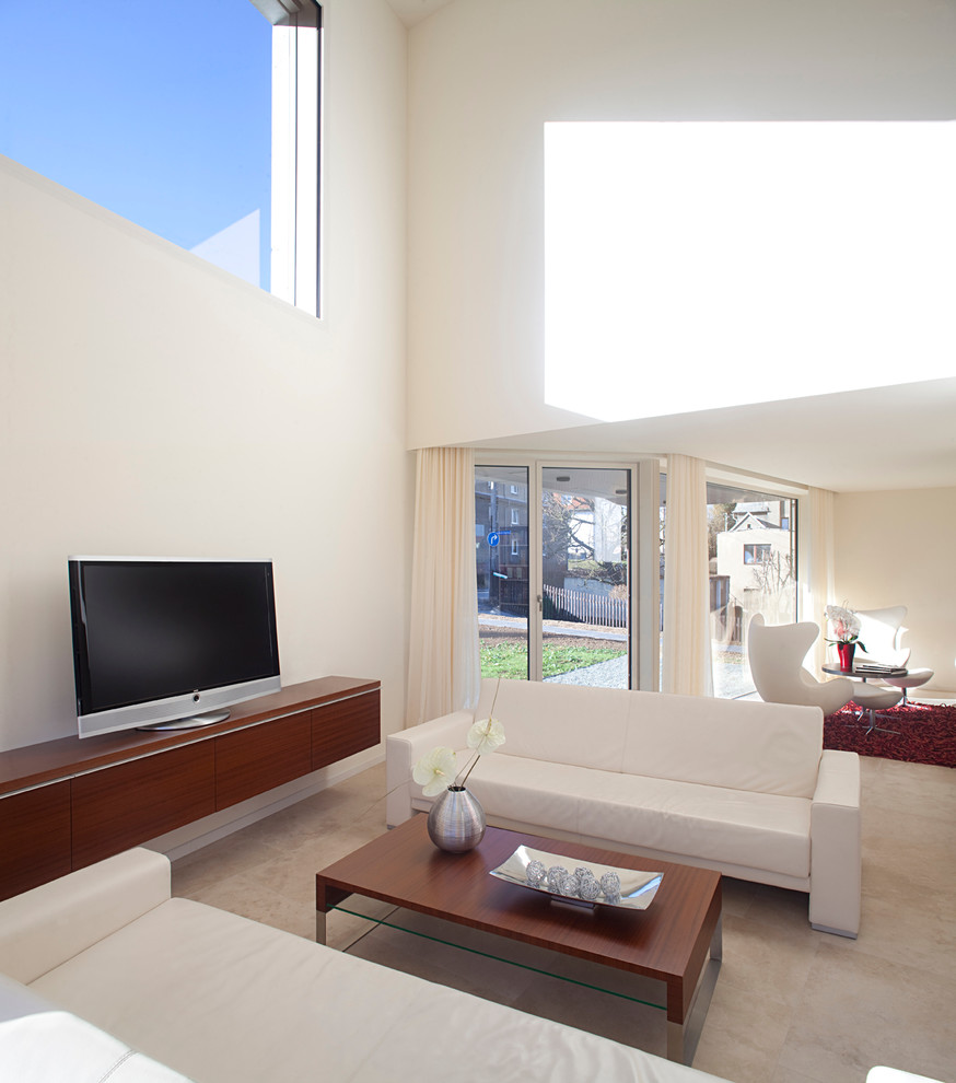 Inredning av ett modernt allrum med öppen planlösning, med ett finrum, vita väggar och en fristående TV
