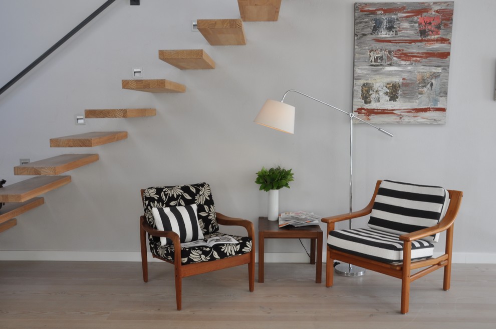 Inspiration pour un petit salon design ouvert avec un mur gris, parquet clair et une salle de réception.