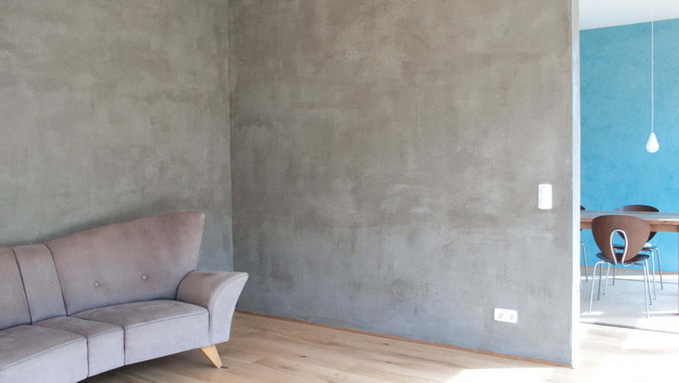 Idées déco pour un salon contemporain de taille moyenne et ouvert avec un mur gris et parquet clair.