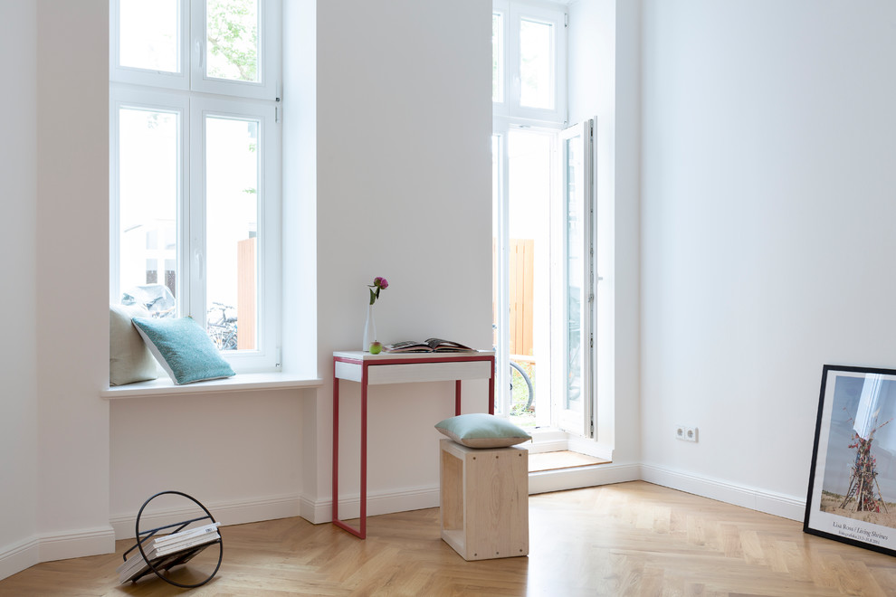 Medium sized scandi open plan games room in Berlin with a reading nook, white walls, medium hardwood flooring, no fireplace, no tv and brown floors.