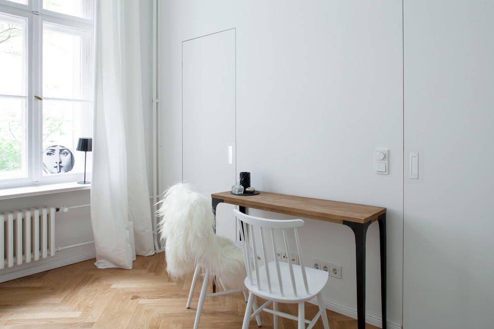 Foto di un piccolo soggiorno moderno stile loft con pareti bianche, pavimento in legno massello medio, nessun camino, nessuna TV e pavimento marrone