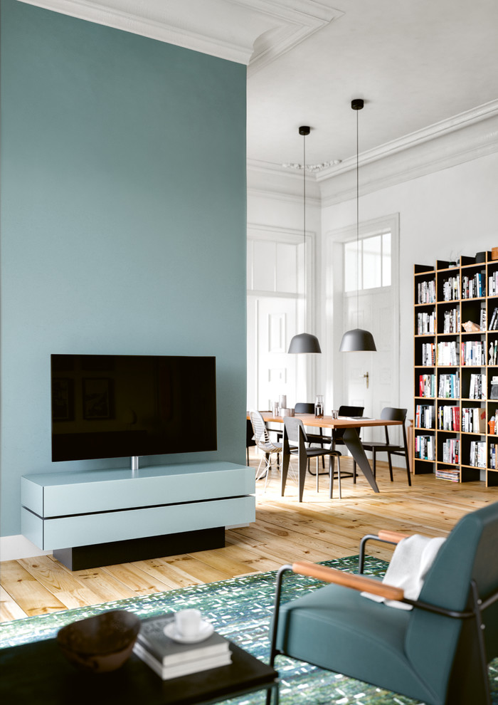 Modelo de biblioteca en casa abierta actual de tamaño medio sin chimenea con paredes blancas, suelo de madera pintada, televisor independiente y suelo beige