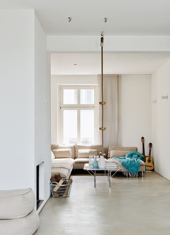 Источник вдохновения для домашнего уюта: изолированная гостиная комната среднего размера в стиле модернизм с белыми стенами, бетонным полом, стандартным камином и фасадом камина из штукатурки
