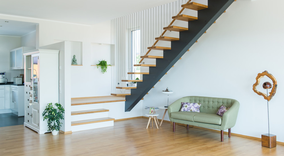 Diseño de salón abierto contemporáneo de tamaño medio con paredes beige y suelo de madera en tonos medios