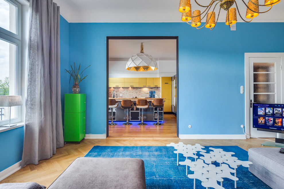 На фото: гостиная комната в современном стиле с синими стенами, светлым паркетным полом и отдельно стоящим телевизором