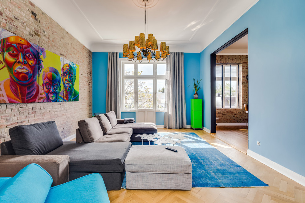 Cette image montre un très grand salon design ouvert avec un mur bleu, parquet clair, aucune cheminée et aucun téléviseur.