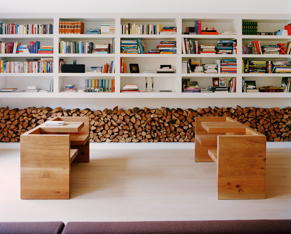Esempio di un soggiorno design di medie dimensioni con libreria, pareti bianche e parquet chiaro