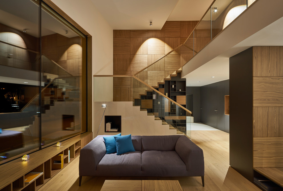 Diseño de sala de estar abierta contemporánea con paredes blancas y suelo de madera en tonos medios