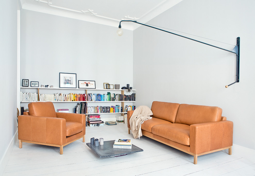 Foto di un piccolo soggiorno design chiuso con libreria, pareti grigie, parquet chiaro, nessun camino e nessuna TV